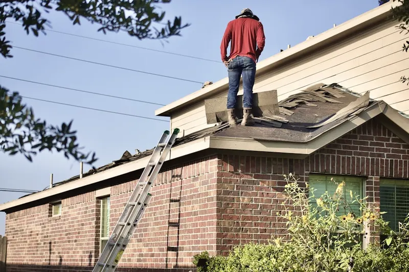 Professional roofer working on a residential roof in College Place